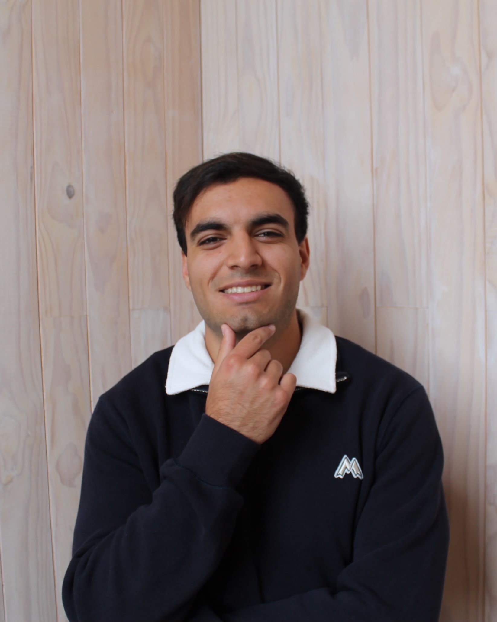 Andrés Benavides con la mano en el rostro, sonriendo